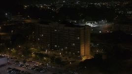 5.7K aerial stock footage of flying away from, then orbiting an office building at nighttime, Memphis, Tennessee Aerial Stock Footage | DX0002_188_043