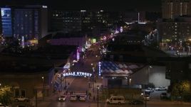 5.7K aerial stock footage descend to reveal the Beale Street sign near clubs and restaurants at nighttime, Downtown Memphis, Tennessee Aerial Stock Footage | DX0002_188_049