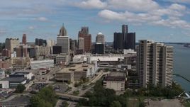 5.7K aerial stock footage focus on skyline in the distance during descent and flyby apartment complex, Downtown Detroit, Michigan Aerial Stock Footage | DX0002_189_009