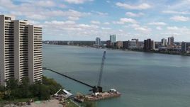 5.7K aerial stock footage flyby apartment complex for view of the Windsor, Ontario skyline across the river, Downtown Detroit, Michigan Aerial Stock Footage | DX0002_189_015