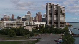 5.7K aerial stock footage descend by apartment complex with view of skyline in Downtown Detroit, Michigan Aerial Stock Footage | DX0002_189_024