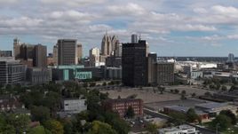 5.7K aerial stock footage descend and pass office buildings, skyline in background, Downtown Detroit, Michigan Aerial Stock Footage | DX0002_189_031