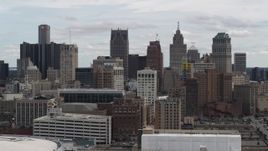 5.7K aerial stock footage ascend above rooftops for stationary view of the city's skyline, Downtown Detroit, Michigan Aerial Stock Footage | DX0002_190_036