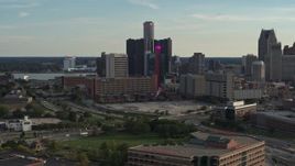5.7K aerial stock footage flyby tall skyscrapers and a hotel at sunset before ascending in Downtown Detroit, Michigan Aerial Stock Footage | DX0002_191_050