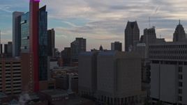 5.7K aerial stock footage descend past skyscrapers at sunset to reveal a hotel, Downtown Detroit, Michigan Aerial Stock Footage | DX0002_192_038