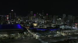 5.7K aerial stock footage fly away from Comerica Park and skyline at night, reveal Ford Field, Downtown Detroit, Michigan Aerial Stock Footage | DX0002_193_046