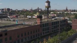 5.7K aerial stock footage of orbiting an abandoned brick building with water tower in Detroit, Michigan Aerial Stock Footage | DX0002_194_047