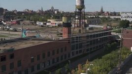 5.7K aerial stock footage of orbiting an abandoned brick building with a water tower on the roof in Detroit, Michigan Aerial Stock Footage | DX0002_194_049