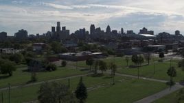 5.7K aerial stock footage focus on the city's skyline while descending toward green lots, Downtown Detroit, Michigan Aerial Stock Footage | DX0002_195_023