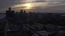 5.7K aerial stock footage flyby the setting sun behind clouds above the Downtown Detroit skyline, Michigan Aerial Stock Footage | DX0002_197_005