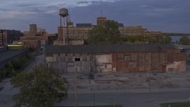 5.7K aerial stock footage ascend by abandoned factory building and water tower at sunset, Detroit, Michigan Aerial Stock Footage | DX0002_197_015