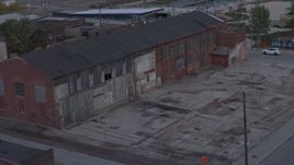 5.7K aerial stock footage ascend away from an abandoned brick building at sunset, Detroit, Michigan Aerial Stock Footage | DX0002_197_051