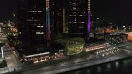5.7K aerial stock footage flyby parking lot to reveal entrance to GM Renaissance Center at night, Downtown Detroit, Michigan Aerial Stock Footage | DX0002_199_003