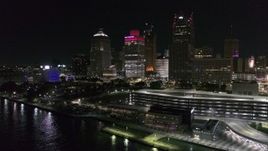5.7K aerial stock footage of Hart Plaza by tall skyscrapers at night, seen from the river, Downtown Detroit, Michigan Aerial Stock Footage | DX0002_199_022