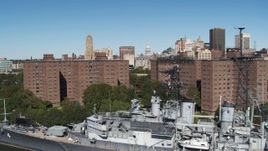 5.7K aerial stock footage ascend past apartment buildings and warship to focus on skyline, Downtown Buffalo, New York Aerial Stock Footage | DX0002_200_015