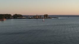 5.7K aerial stock footage flying toward a sailboat on Lake Erie near lighthouse at sunset, Buffalo, New York Aerial Stock Footage | DX0002_204_015