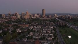 5.7K aerial stock footage of Seneca One Tower and skyline seen while passing homes at twilight, Downtown Buffalo, New York Aerial Stock Footage | DX0002_204_036