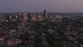 5.7K aerial stock footage of Seneca One Tower and skyline seen while descending past homes at twilight, Downtown Buffalo, New York Aerial Stock Footage | DX0002_204_037