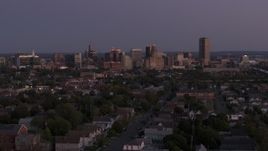5.7K aerial stock footage of the skyline seen while ascending past apartments and homes at twilight, Downtown Buffalo, New York Aerial Stock Footage | DX0002_204_040