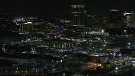5.7K aerial stock footage of flying by parking lots near the skyscraper at night, Downtown Buffalo, New York Aerial Stock Footage | DX0002_205_032