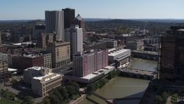 5.7K aerial stock footage ascend over river for view of hotel near the city's skyline, Downtown Rochester, New York Aerial Stock Footage | DX0002_206_006
