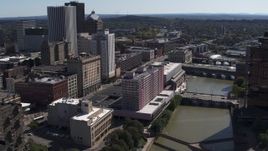 5.7K aerial stock footage reverse view of riverfront hotel and city's skyline, Downtown Rochester, New York Aerial Stock Footage | DX0002_206_007