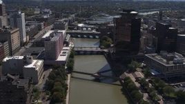 5.7K aerial stock footage fly away from riverfront hotel across Genessee River from office building, Downtown Rochester, New York Aerial Stock Footage | DX0002_206_011