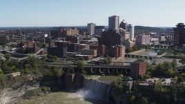 5.7K aerial stock footage fly away from the city's skyline to reveal waterfalls on the river, Downtown Rochester, New York Aerial Stock Footage | DX0002_206_029