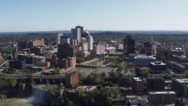 5.7K aerial stock footage focus on skyline by river bridges while flying near waterfall, Downtown Rochester, New York Aerial Stock Footage | DX0002_207_007