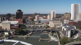 5.7K aerial stock footage of passing bridges over the river and city buildings, Downtown Rochester, New York Aerial Stock Footage | DX0002_207_033