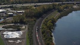 5.7K aerial stock footage of tracking a train on the shore of a lake in Syracuse, New York Aerial Stock Footage | DX0002_211_030