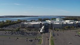 5.7K aerial stock footage of flying away from the Destiny USA shopping mall with lake in the background, Syracuse, New York Aerial Stock Footage | DX0002_212_021