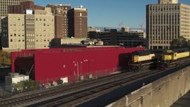 5.7K aerial stock footage descend and track a train in Downtown Syracuse, New York Aerial Stock Footage | DX0002_214_003
