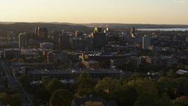 5.7K aerial stock footage of downtown seen while descending by Syracuse University at sunset, New York Aerial Stock Footage | DX0002_214_019