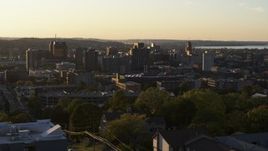 5.7K aerial stock footage of downtown seen while ascending by Syracuse University at sunset, New York Aerial Stock Footage | DX0002_214_020