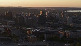 5.7K aerial stock footage stationary view then flyby office and city buildings in Downtown Syracuse at sunset, New York Aerial Stock Footage | DX0002_214_028