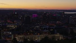 5.7K aerial stock footage of office and city buildings lit up for the evening in Downtown Syracuse at sunset, New York Aerial Stock Footage | DX0002_214_036