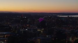 5.7K aerial stock footage of flying by office and city buildings lit up for the evening in Downtown Syracuse at sunset, New York Aerial Stock Footage | DX0002_214_037