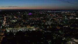 5.7K aerial stock footage of flying by city buildings lit up for the evening in Downtown Syracuse at twilight, New York Aerial Stock Footage | DX0002_215_002