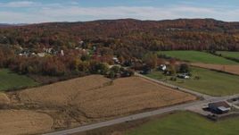 5.7K aerial stock footage of flying away from a small town beside a forest in autumn, Orwell, Vermont Aerial Stock Footage | DX0002_217_010