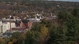 5.7K aerial stock footage of flying by autumn trees with smoke stack in the background, Montpelier, Vermont Aerial Stock Footage | DX0002_218_033