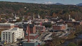5.7K aerial stock footage of flying by trees to reveal office buildings by a smoke stack, Montpelier, Vermont Aerial Stock Footage | DX0002_218_034