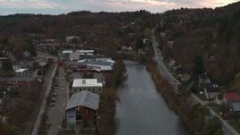 5.7K aerial stock footage of flying by and away from the river and Berlin Street at sunset, Montpelier, Vermont Aerial Stock Footage | DX0002_220_035