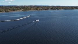 5.7K aerial stock footage of tracking a speedboat racing past a breakwater on Lake Champlain near Burlington, Vermont Aerial Stock Footage | DX0002_224_026