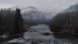 5.7K aerial stock footage of flying low over the river toward snowy mountains in Leavenworth, Washington Aerial Stock Footage | DX0002_227_001