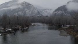 5.7K aerial stock footage of following the river to approach snowy mountains in Leavenworth, Washington Aerial Stock Footage | DX0002_227_014