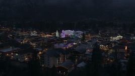 5.7K aerial stock footage ascend from trees to reveal Christmas trees and lights at night in Leavenworth, Washington Aerial Stock Footage | DX0002_228_006
