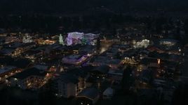 5.7K aerial stock footage descend and slowly fly away from Christmas trees and lights at night in Leavenworth, Washington Aerial Stock Footage | DX0002_228_013