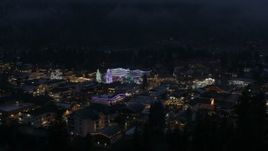 5.7K aerial stock footage ascend to reveal town with Christmas trees and lights at night in Leavenworth, Washington Aerial Stock Footage | DX0002_228_014
