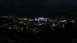 5.7K aerial stock footage ascend from trees to reveal Christmas trees and lights at night, Leavenworth, Washington Aerial Stock Footage | DX0002_228_021